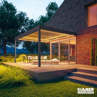 Terrassenüberdachungen Moderne Terrasse mit Überdachung, Sitzbereich und umgebender Landschaft bei Dämmerung.